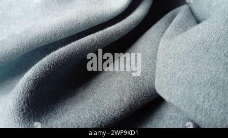 Close-up of velvety thick fabric for curtains of gray-blue color pleated with the play of chiaroscuro Stock Photo