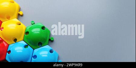 Multi-colored details from the childrens designer on a gray background.Red, yellow, green, blue plastic discs for the development of fine motor skills Stock Photo