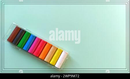Multi-colored new plasticine in plastic packaging on a light green background. Plasticine plates of red, pink, green, white, yellow, brown, blue. Set Stock Photo