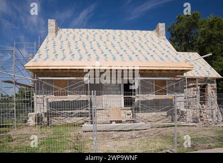 Restoration work on an old 1800s Canadiana style fieldstone home in summer, Montreal, Quebec, Canada. Stock Photo