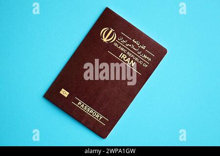 Red Islamic Republic of Iran passport on blue background close up. Tourism and citizenship concept Stock Photo