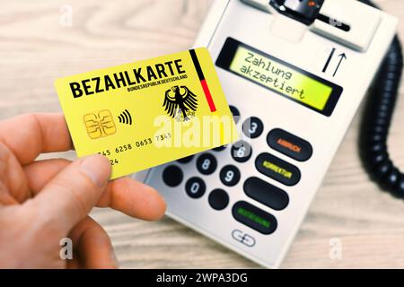 FOTOMONTAGE, Bezahlkarte für Geflüchtete und Asylsuchende vor einem Kartenlesegerät, Symbolfoto *** PHOTOMONTAGE, payment card for refugees and asylum seekers in front of a card reader, symbolic photo Stock Photo