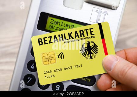 FOTOMONTAGE, Bezahlkarte für Geflüchtete und Asylsuchende vor einem Kartenlesegerät, Symbolfoto *** PHOTOMONTAGE, payment card for refugees and asylum seekers in front of a card reader, symbolic photo Stock Photo