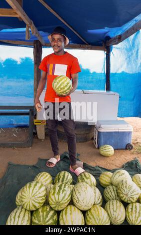 african street vendor selling watermelons on the side of the road in a shack Stock Photo