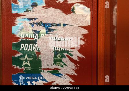 Moscow, Russia. 2nd of March, 2024. A poster promoting contract army service and reading 'Our job, defending the homeland' adorns a door of a shop in residential area of Moscow, Russia Stock Photo