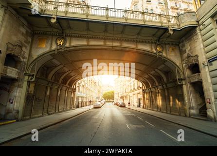 Hohe Brücke (High Bridge) in rays of morning sun - view from Tiefer Graben street. Diminsihing perspective view of empty street below the bridge. Stock Photo