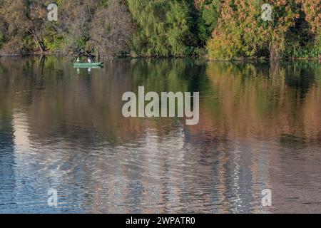 Leisure boating on the Colorado River in Austin TX USA.Reflections of buildings and leaves on the water. Stock Photo