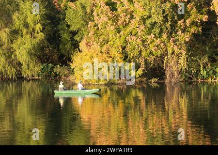 Leisure boating on the Colorado River in Austin TX USA.Reflections of buildings and leaves on the water. Stock Photo