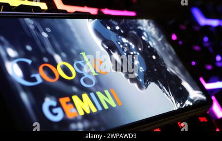 Viersen, Germany - February 9. 2024: Closeup of Smartphone screen with logo lettering of Google Gemini on computer keyboard Stock Photo