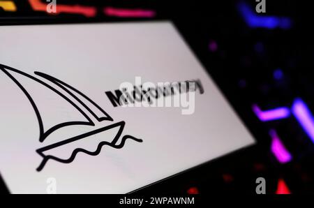 Viersen, Germany - February 9. 2024: Closeup of Smartphone screen with logo lettering of Midjourney AI text-to-image tool on computer keyboard Stock Photo