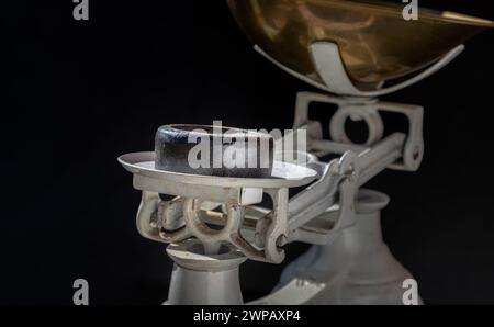 Cast iron weights on Old obsolete manual weighing scales and Iron Brass Tray on dark background. Classic weight scale, Antique balance scales, Space f Stock Photo