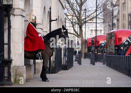 Ceremonial parade of a mounted Horse Guard sentry on Whitehall, on 6th March 2024, in London, England. Two mounted sentries guard the entrance to Horse Guards on Whitehall from 10:00am until 4:00pm. The King’s Life Guard is conducted by soldiers of the Household Cavalry Mounted Regiment at Horse Guards. Horse Guards is named after the troops who have mounted The King’s Life Guard here since the Restoration of King Charles II in 1660. Stock Photo