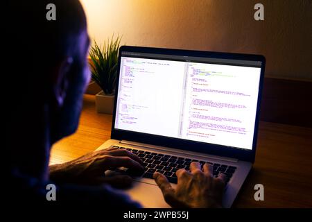 Developer programmer writing html javascript code in a laptop. Stock Photo