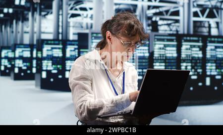 Proficient system administrator looking around revolutionary data center, preparing to start comission on damaged high tech server rackmounts in order to ensure ideal operations Stock Photo