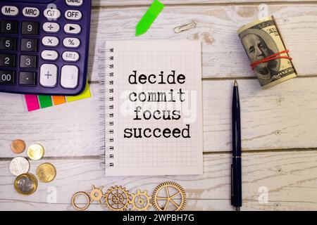 Decide commit focus succeed symbol. Concept word Decide Commit Focus Succeed on beautiful white paper. Beautiful brown paper background. Business deci Stock Photo