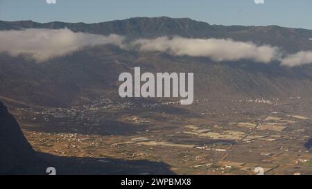 An amazing aerial view of a green valley with a quaint village and misty mountains on the island of El Hierro, a biosphere reserve and a paradise for Stock Photo