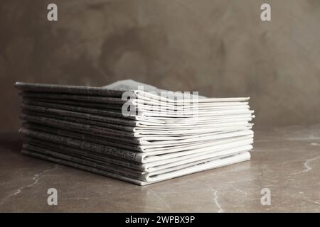 Stack of newspapers on marble table. Journalist's work Stock Photo