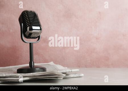 Newspapers and vintage microphone on table, space for text. Journalist's work Stock Photo