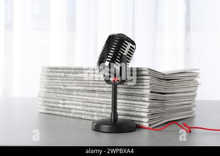 Newspapers and vintage microphone on grey table. Journalist's work Stock Photo