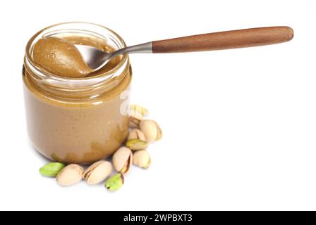 Tasty nut paste in jar, spoon and pistachios isolated on white Stock Photo