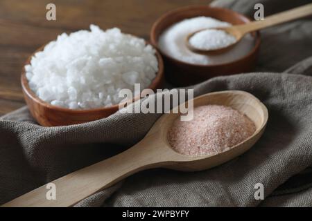 Different types of organic salt on wooden table, closeup Stock Photo