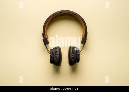 Retro style wireless over-ear headphones on yellow background Stock Photo