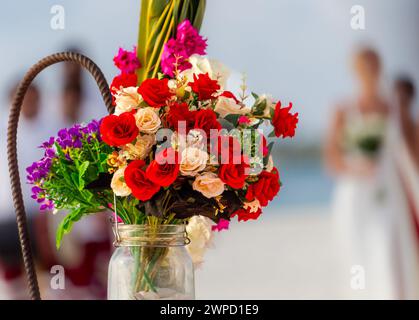 A glass jar with blowers, with a bride in the background Stock Photo