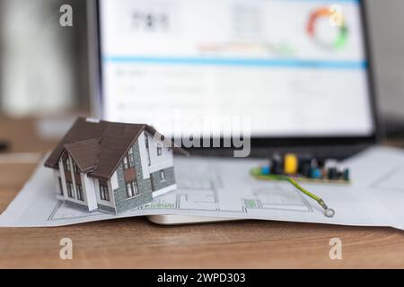 A real estate model and a computer are on the table. Stock Photo