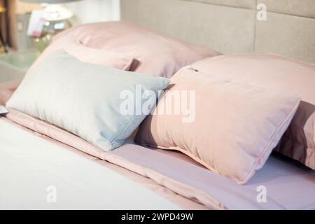 Soft pillows on a large bed in pastel colors close up Stock Photo