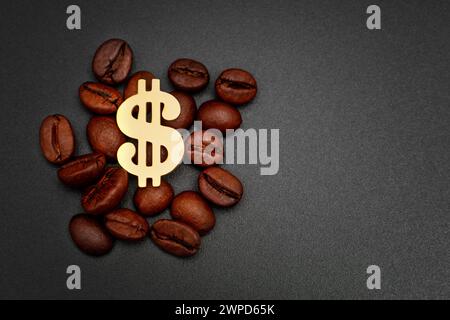 Golden dollar sign placed within a pile of roasted coffee beans against a black backdrop. Coffee roasting and supply industry related background. Stock Photo