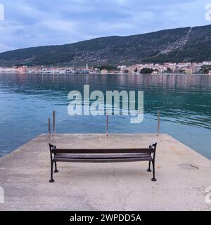 Calm sea near Cres Croatia after sunset in springtime, bench on concrete platform Cres Croatia Stock Photo