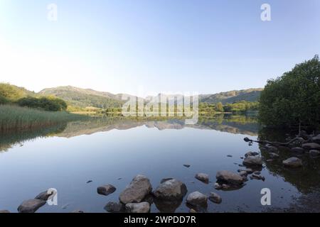 UK, Cumbria, Lake District, the Langdale pikes at dawn reflected in Elterwater. Stock Photo