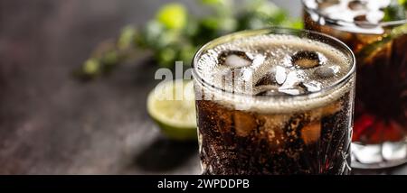 Bubbling Coke drink with ice cubes on the bar counter. Stock Photo