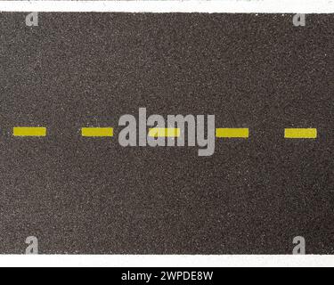 Aerial view of asphalt with a yellow dashed dividing line and white continuous lines delimiting the road Stock Photo