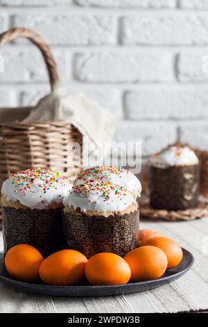Decorated Easter cakes and yellow colored eggs on a plate. Stock Photo