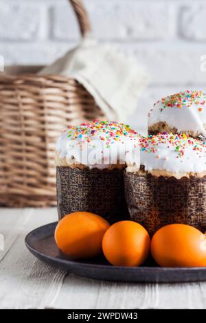 Glaze decorated Easter cakes and yellow colored eggs on a plate. Stock Photo
