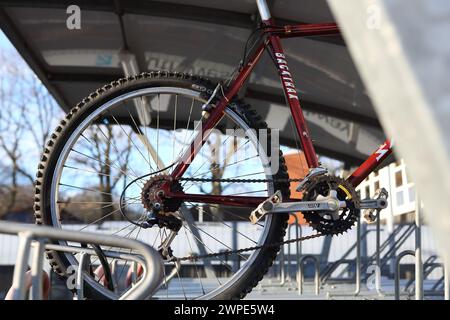 Rear bike wheel with gears cycle parking facilities at Farnborough Main railway station with bike racks, Farnborough, Hampshire, UK Stock Photo