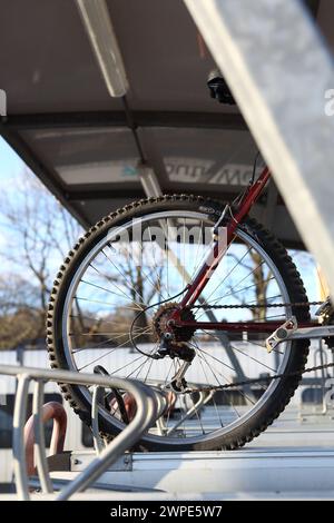 Rear bike wheel with gears cycle parking facilities at Farnborough Main railway station with bike racks, Farnborough, Hampshire, UK Stock Photo