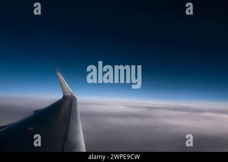 Airplane wing at a great height against clear and cloudy blue sky.  Useful horizontal banner Stock Photo