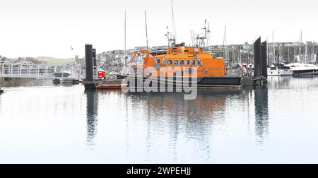 Lifeboats at anchor in Brixham marina, Devon, on standby showing full extent of what the lifeboat looks like in size and colour Stock Photo