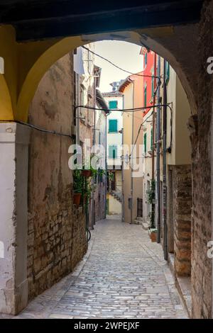 beautiful street of Rovinj Croatia with cobblestone looking through an arch tunel . Stock Photo