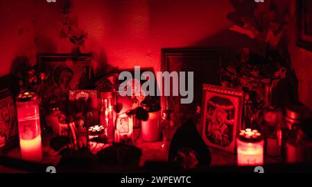 Altar with icons and burning candles. Lighting a candle in front of the Orthodox icon of the Madonna in Greece. Religious symbol. Image of the Saint Stock Photo