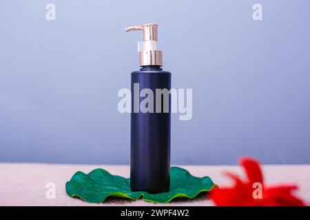 Cosmetic bottle isolated on Blue. under Lotus Leaf Stock Photo