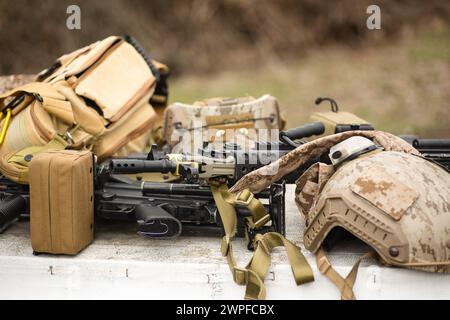 airsoft replica weapon and top camouflage helmet AOR 1, machine gun on a natural background Stock Photo