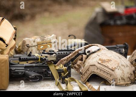 airsoft replica weapon and top camouflage helmet AOR 1, machine gun on a natural background Stock Photo