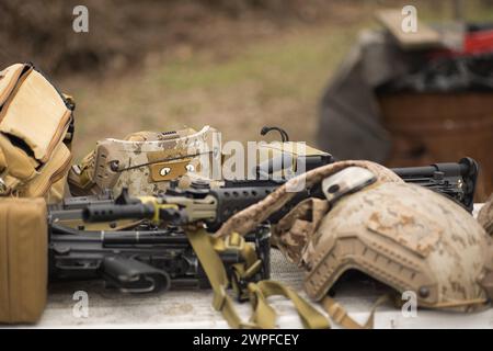 airsoft replica weapon and top camouflage helmet AOR 1, machine gun on a natural background Stock Photo