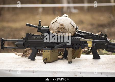 airsoft replica weapon and top camouflage helmet AOR 1, machine gun on a natural background Stock Photo