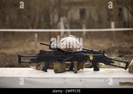 airsoft replica weapon and top camouflage helmet AOR 1, machine gun on a natural background Stock Photo