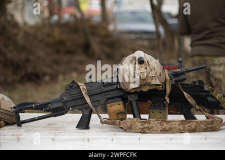 airsoft replica weapon and top camouflage helmet AOR 1, machine gun on a natural background Stock Photo