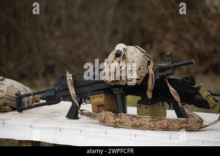 airsoft replica weapon and top camouflage helmet AOR 1, machine gun on a natural background Stock Photo